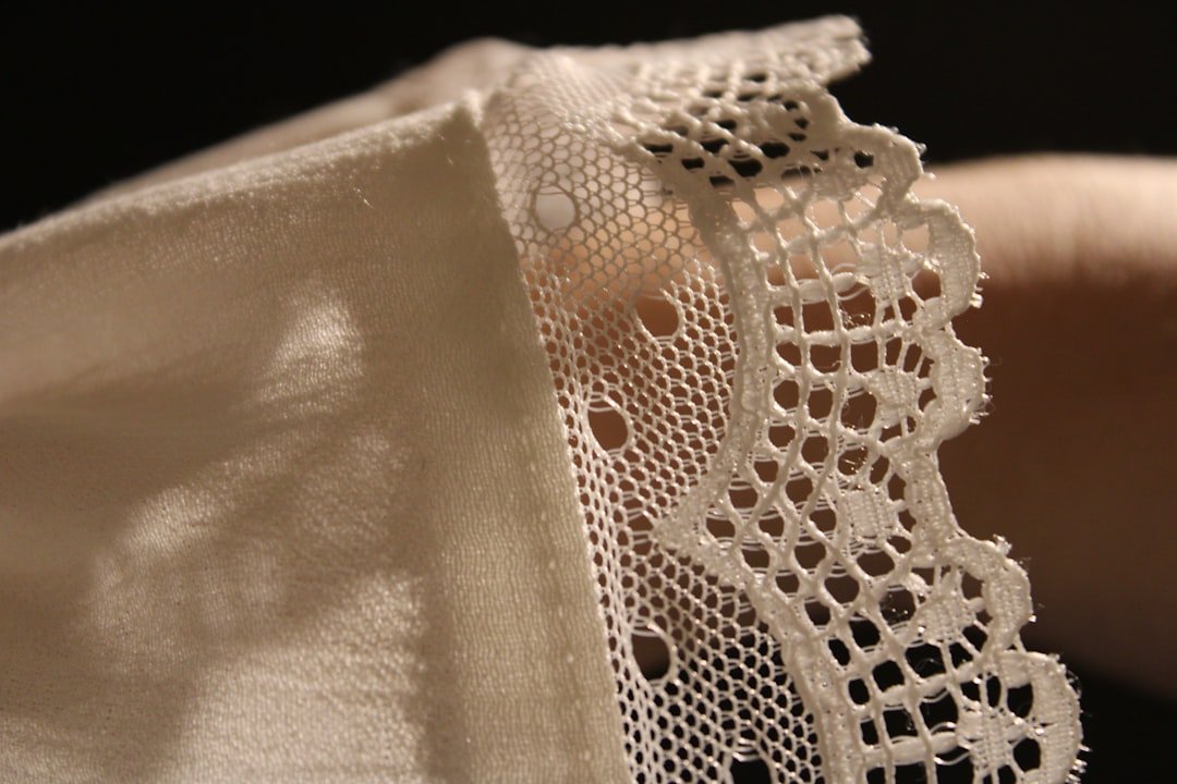 a-close-up-of-a-persons-hand-holding-a-piece-of-lace-4olc1yh7nve