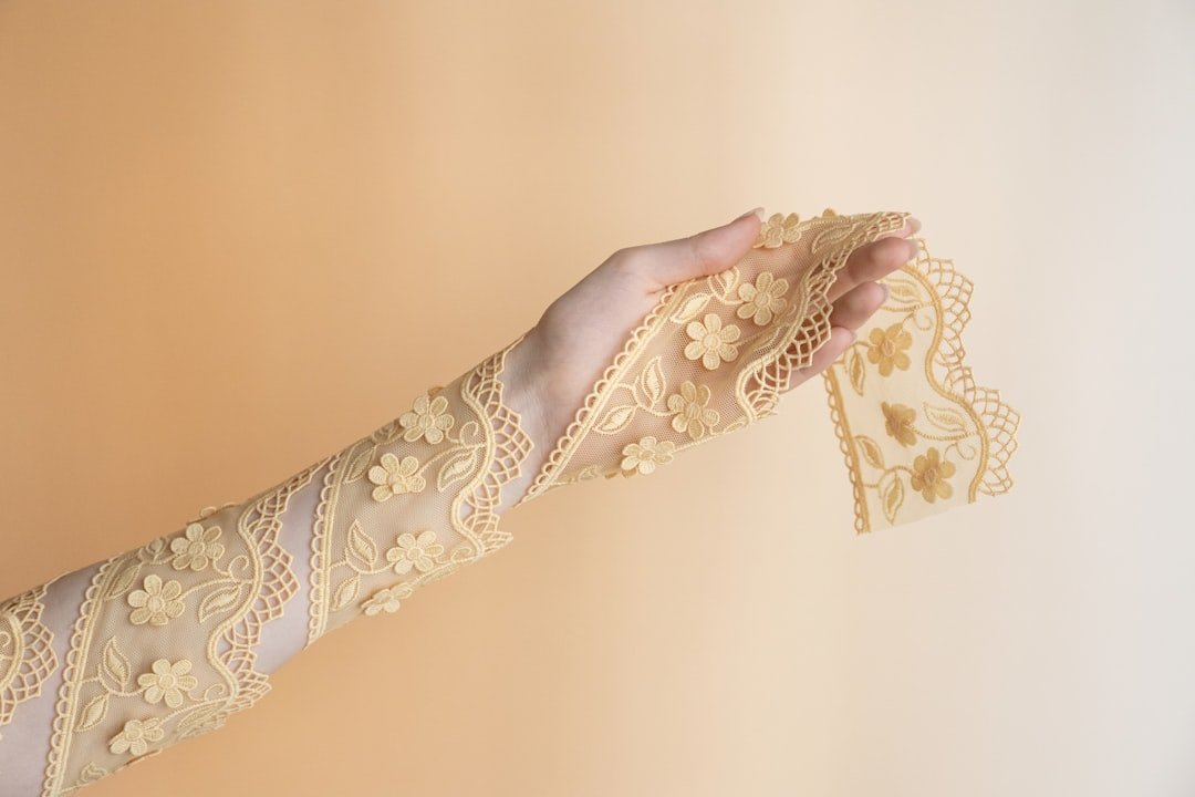 hand-holding-delicate-yellow-lace-fabric-with-floral-pattern-q-jvoqz9e0w